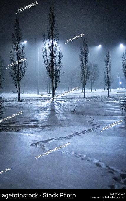 Footsteps in the snow. Foggy night on a suburban street in winter