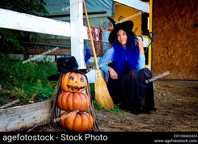 Halloween celebration witch and pumpkin figure sit by the fence