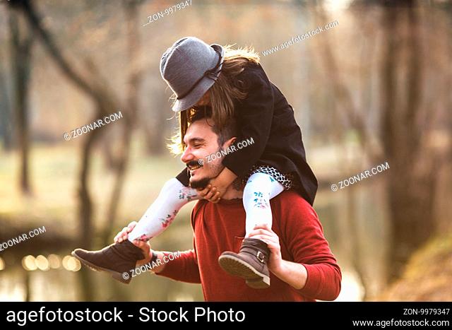A father carrying his daughter up on his shoulders