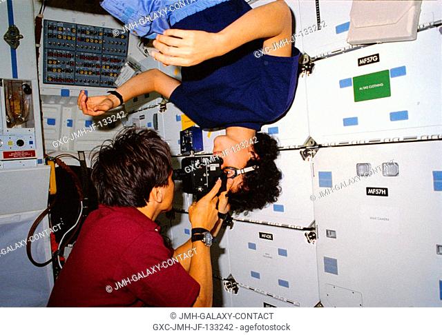 Astronaut Franklin R. Chang-Diaz performs an eye examination on astronaut Ellen S. Baker, both STS-34 mission specialists
