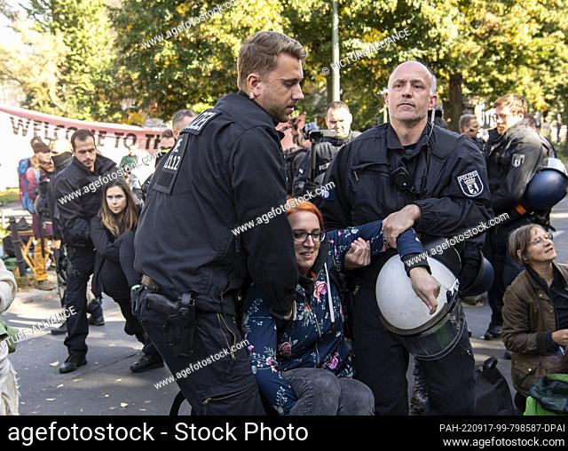 17 September 2022, Berlin: A member of the environmental protection group Extinction Rebellion is carried away by police officers during a blockade at the...
