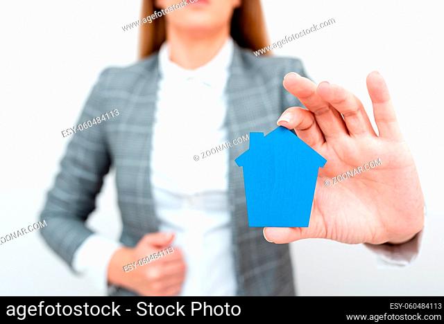 A Young Lady Businesswoman Holding Presenting Home In Business Outfit