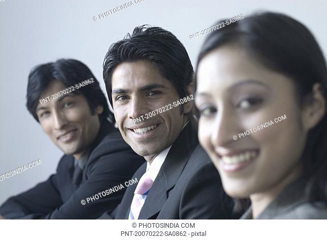 Portrait of a businesswoman and two businessmen smiling