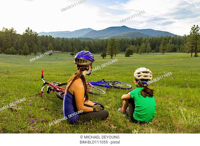 Mother and daughter sitting in meadow