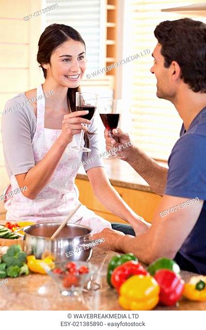 Portrait of a couple having a glass of wine while cooking