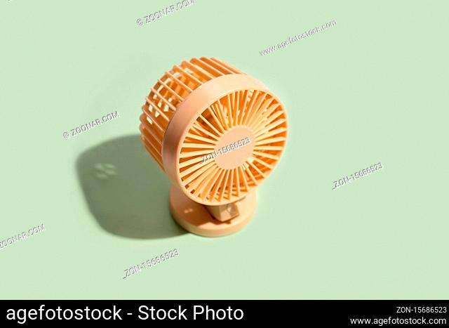Minimal summer background of mini fan on green background. Isometric trendy style with shadows. High quality photo