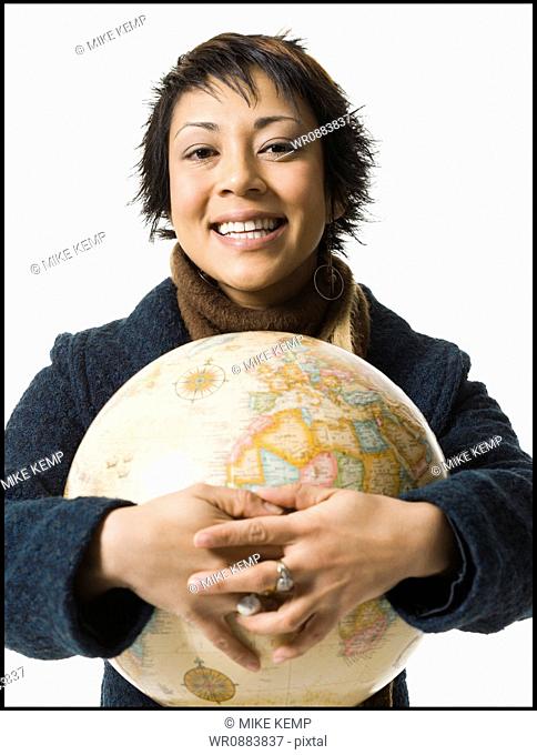 Portrait of a young woman holding a globe