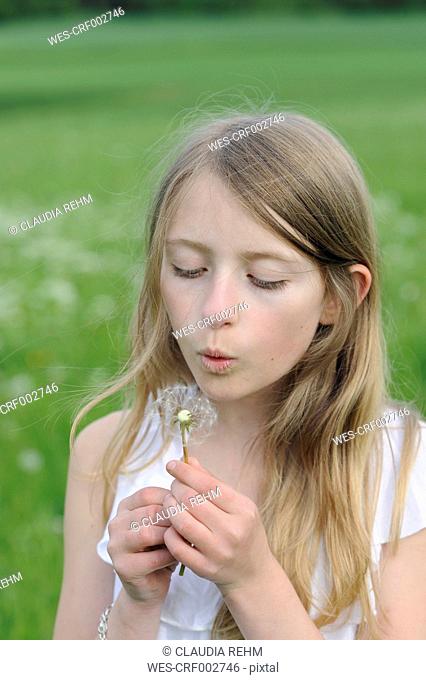 Portrait of girl blowing blowball