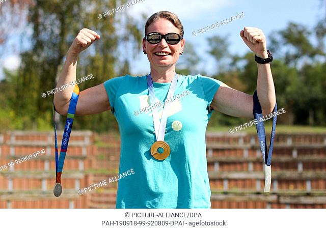 12 September 2019, Saxony-Anhalt, Kelbra: The former shot-putter Nadine Kleinert proudly shows her medals from Athens (l-r, silver, 2004), Helsinki (gold