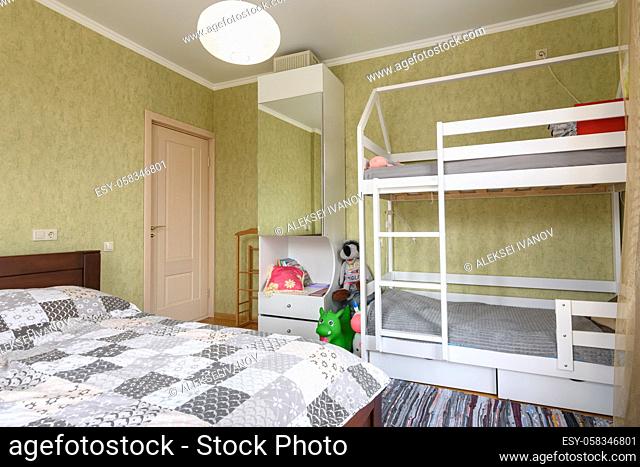 Bedroom interior with a large double bed and a children's bunk bed