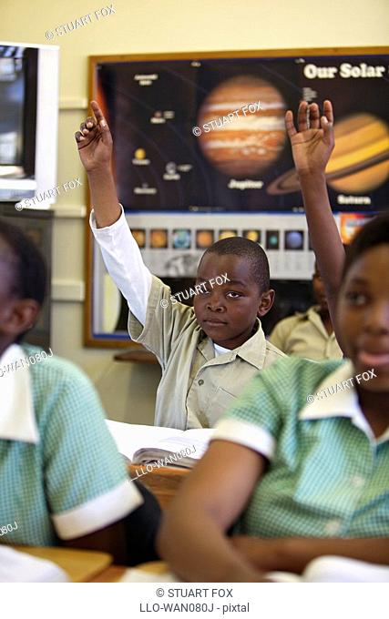 Schoolboy with his hand raised during classtime, KwaZulu Natal Province, South Africa
