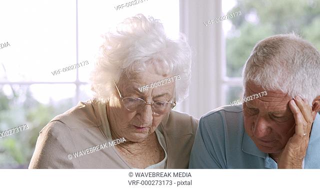 Worried senior couple talking