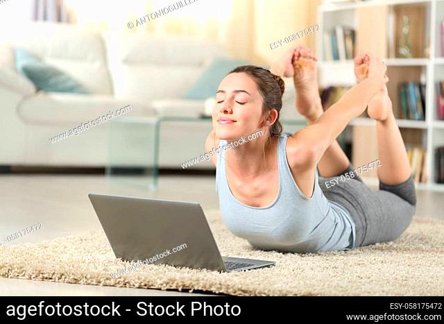 Woman e-learning yoga exercise using a laptop