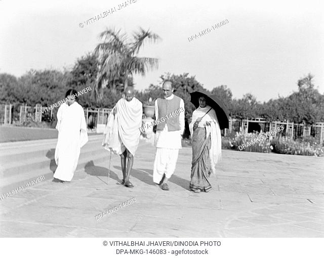 Sushila Nayar ; Mahatma Gandhi ; Mahadev Desai and Rajkumari Amrit Kaur walking at Birla House ; New Delhi ; 1939 ; India NO MR