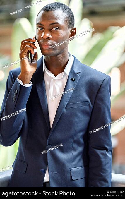 Businessman talking on mobile phone at railroad station