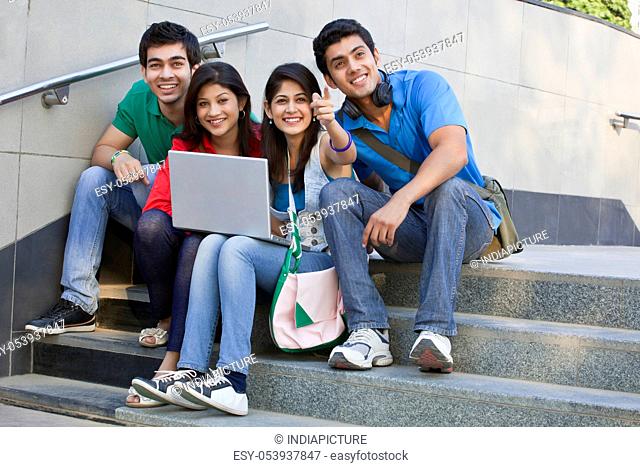 College students with laptop looking away