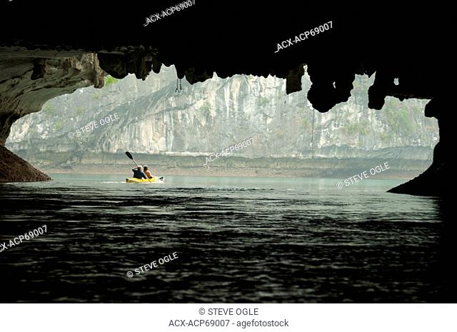 Kayaking through a rock arch in Lan Ha Bay, Vietnam