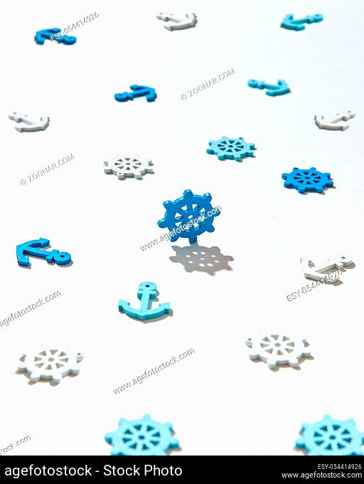 Toys pattern from marine symbols ship's anchors and rudders on a light background with hard shadows. Flat lay