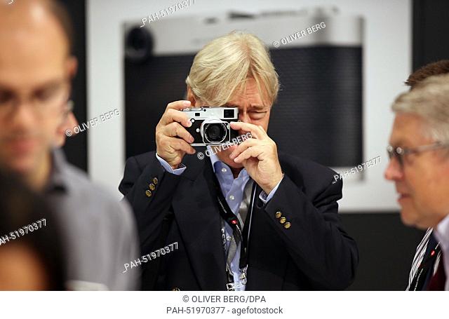 A trade fair visitor tests a Leica M camera in Cologne, Germany, 16 September 2014. The world's largest trade fair for the photographic and imaging industries...