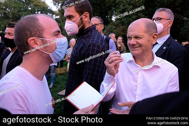 05 September 2021, Saxony, Leipzig: Olaf Scholz (r.), SPD candidate for chancellor, signs autographs at an election campaign event