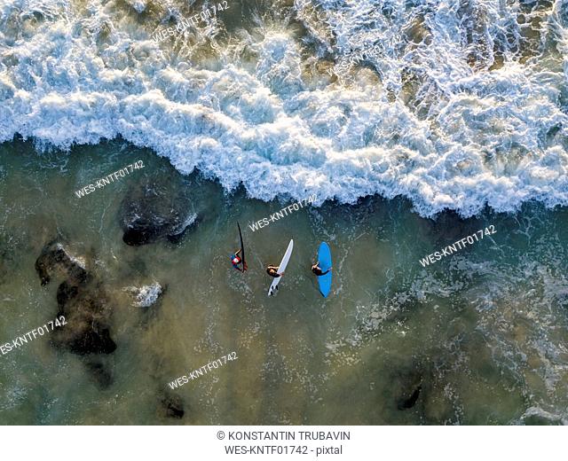 Indonesia, Bali, Aerial view of Dreamland beach, three surfers from above