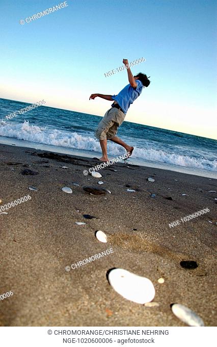 Young Man throwing Stones into Water