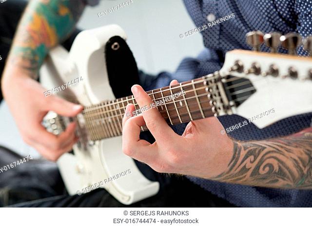 Handsome man playing on guitar