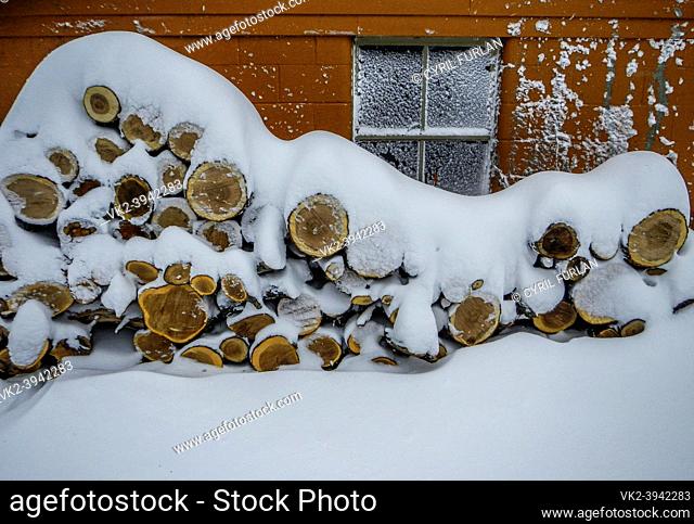 Heavy snow covering stack of firewood in winter