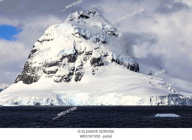 Glaciers, pyramidal mountain peak and dramatic clouds and sky, Cape Errera, Wiencke Island, Antarctic Peninsula, Antarctica, Polar Regions
