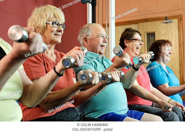 Older people lifting weights in gym