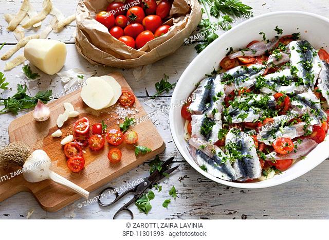 Sardine bake with potatoes, garlic, cherry tomatoes and parsley