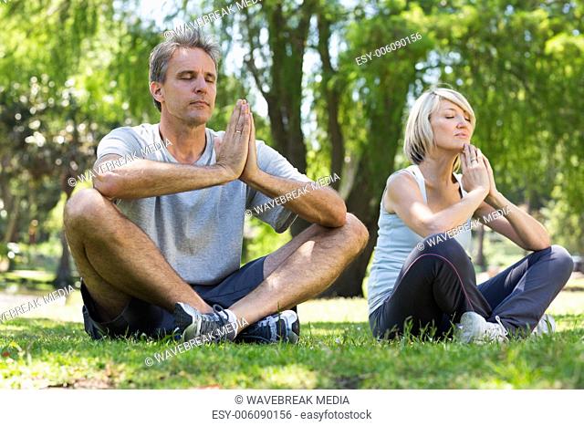 Couple meditating in park