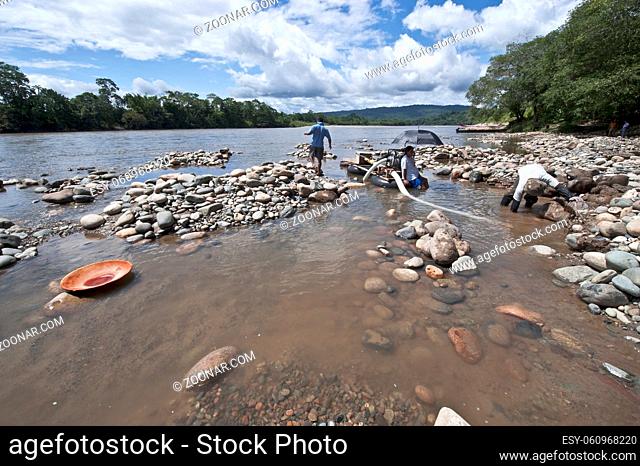 Misahualli, Napo Province, Ecuador - December 27, 2010: Local Indians People panning for Gold with wood batea (Spanish for