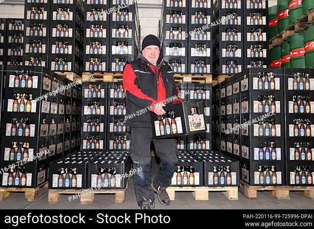 13 January 2022, Saxony-Anhalt, Magdeburg: Brewery employee Dennis Conrad fetches a crate of bottled beer from the warehouse in the ""Sudenburger Brauhaus""