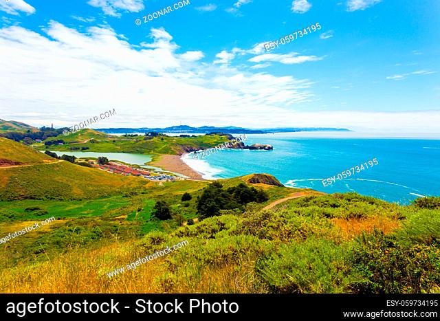 San Francisco in distant background seen from atop the Marin Headlands above Fort Cronkhite and Rodeo Beach along the coastal trail on a summer day in...