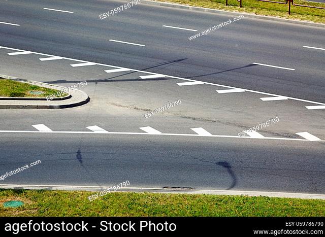Closeup of asphalt road with white stripes