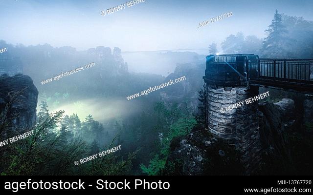 Nocturnal view from the Bastei bridge in the misty Elbe Sandstone Mountains