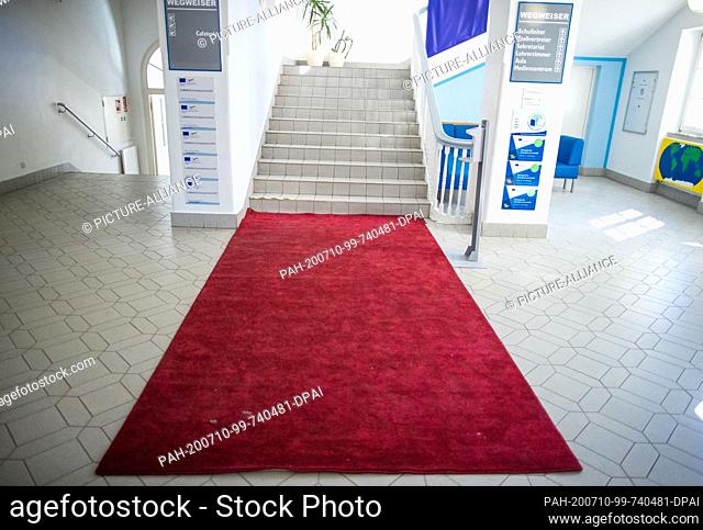 23 June 2020, Mecklenburg-Western Pomerania, Neustrelitz: A red carpet is laid out in the staircase of the Gymnasium Carolinum in Neustrelitz