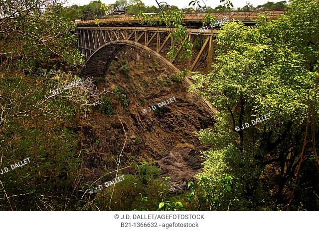 Africa-Zimbabwe- The Victoria Falls Bridge crosses the Zambezi River just below the Victoria Falls and is built over the Second Gorge of the falls  As the river...