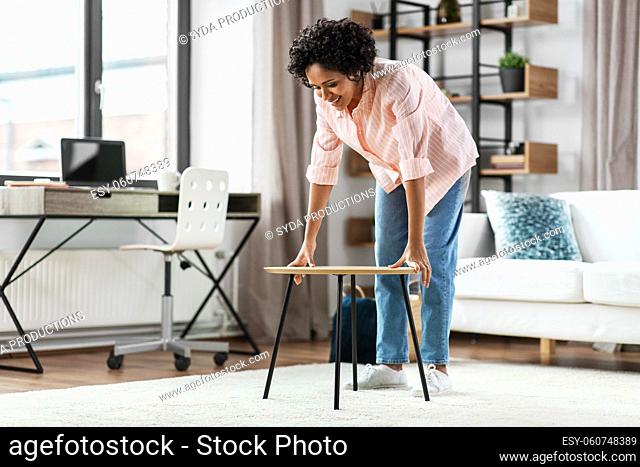 smiling woman placing coffee table at home