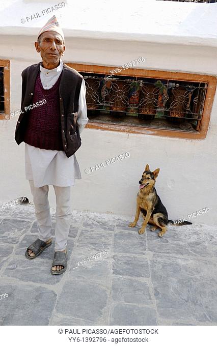 nepalese man and his dog, boudhanath , one of the holiest Buddhist sites in Kathmandu , Nepal