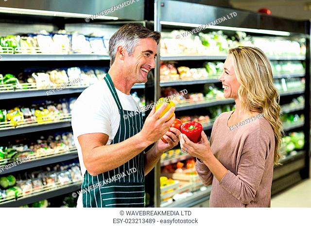 Smiling blonde woman buying a vegetables at supermarket