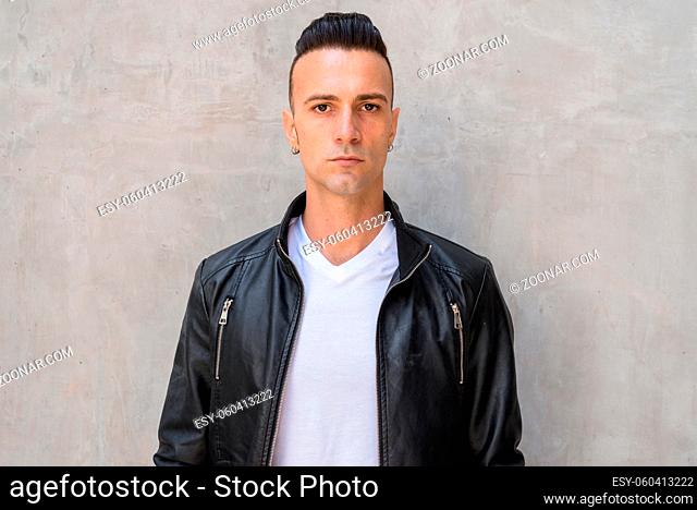 Portrait of handsome young confident Italian man with undercut
