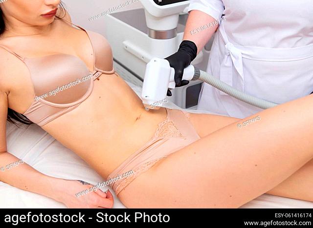 The process of laser hair removal of the female body, the abdomen area. Professional and safe cosmetology. Body care concept