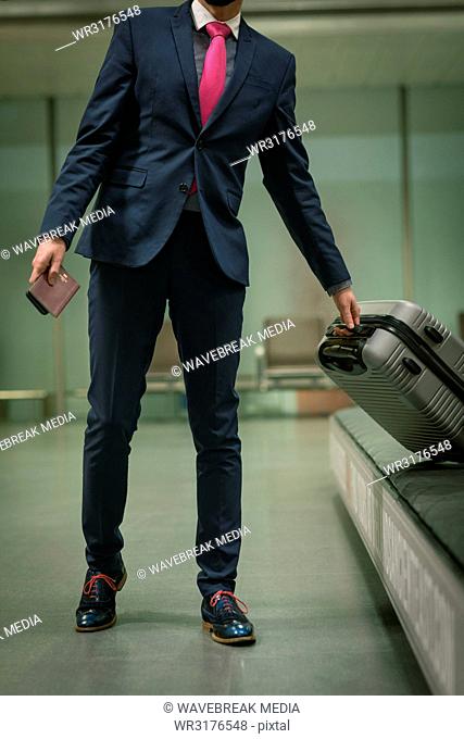 Businessman taking their baggage from baggage carousel