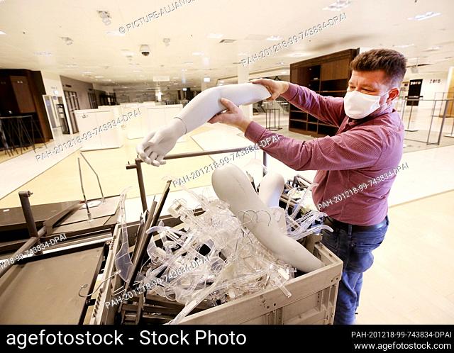 18 December 2020, North Rhine-Westphalia, Essen: Left-behind department store inventory is cleared away by Norbert Schmitt at the closed Kaufhof branch at the...