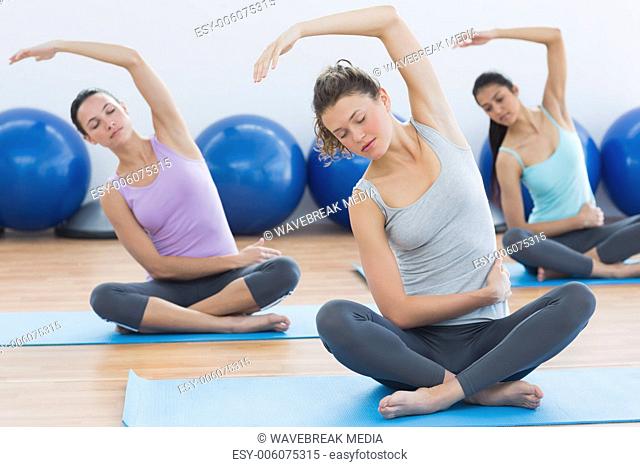 Women with eyes closed exercising at fitness studio