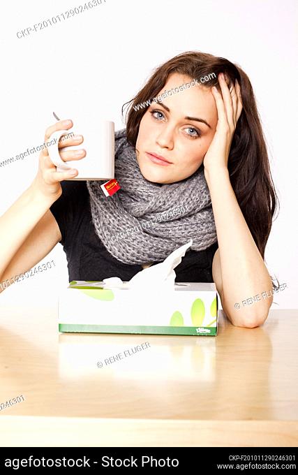 A beautiful young woman, lady, girl, cold, runny nose, headache, tissues, paper hankies, cup of tea, scarf  (CTK Photo/Rene Fluger) MODEL RELEASED, MR