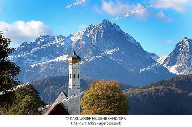 The pilgramage church Sankt Coloman stands amid the autmnal landscape in front of the snow-covered Alps near Hohenschwangau, Germany, 17 October 2013