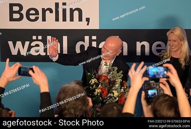12 February 2023, Berlin: CDU top candidate Kai Wegner stands with a bouquet of flowers in his hand next to his partner Kathleen Kantar on stage at the CDU...